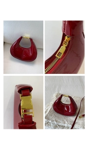Détail du sac demi-lune en cuir verni bordeaux avec garniture dorée et fermeture éclair