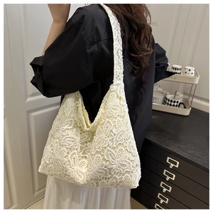 Vue détaillée de la texture en dentelle florale et du motif crochet sur ce sac crème