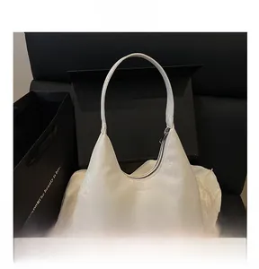 Detail showing the white snake pattern textured leather shoulder bag with zipper closure