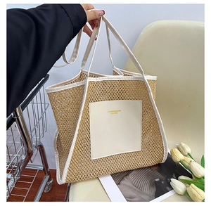 Detail of woven straw tote bag with cream leather trim and gold embossed logo patch