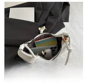 Detail view of woven leather bag interior with smartphone, earbuds and daily items