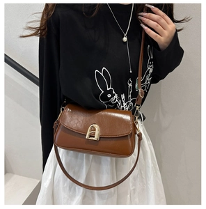 Détail d'un sac à bandoulière en cuir marron vintage avec un fermoir doré élégant