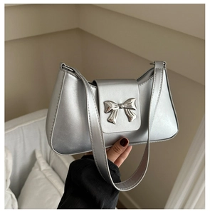 Silver metallic shoulder bag with a butterfly buckle detail on a white background