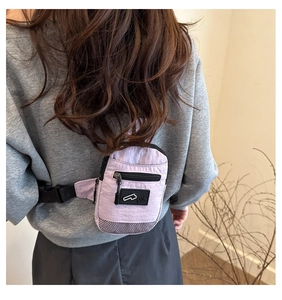 Détail d'un sac bandoulière en nylon violet avec sangle réglable et empiècement mesh