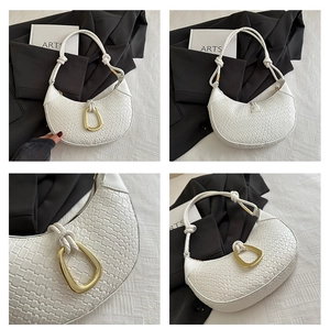 Detail of white woven crescent bag featuring a matte gold geometric clasp and rope handle