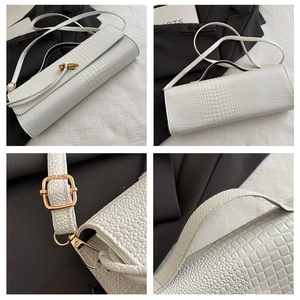 Detailed close-up showing white crocodile pattern texture and golden twist lock on handbag