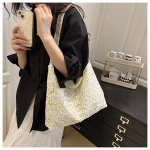 Gros plan sur un sac cabas en dentelle blanche crochetée avec texture florale
