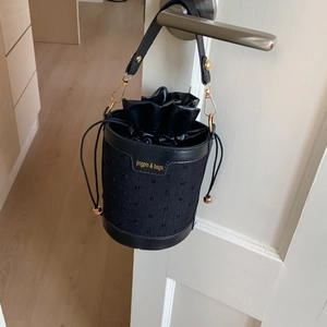Détail du sac seau noir avec fermeture à cordon et logo jingpin & bags imprimé
