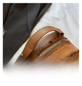 Détail du mini sac à dos en cuir marron avec motif d'ours et fermeture éclair dorée