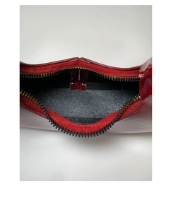 Détail du sac cabas en cuir verni rouge avec doublure grise et fermeture dorée
