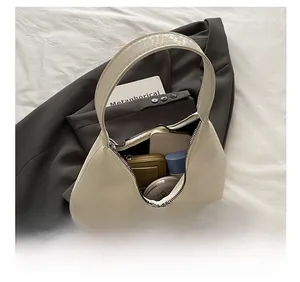 Top view of cream hobo bag showing spacious interior with phone, wallet, and cosmetics