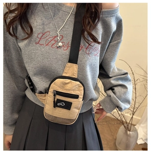Détail du sac de poitrine compact en nylon beige avec sangle réglable porté par un mannequin