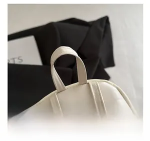 Dettaglio del manico rinforzato con doppia cucitura sullo zaino in pelle PU bianca