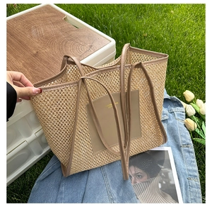 Close-up of a woven straw tote bag with leather straps and patch on a blue denim jacket