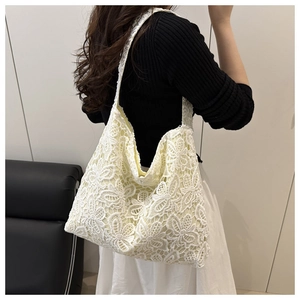 Détail du sac cabas en dentelle blanche avec broderie florale et doublure en tissu jaune