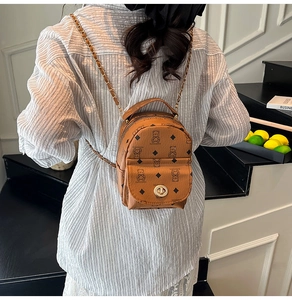 Détail du mini sac à dos en cuir marron avec imprimé d'ours et bandoulière dorée