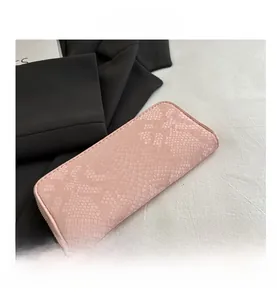Detailed view of light pink snake pattern texture on women's long wallet with zip closure