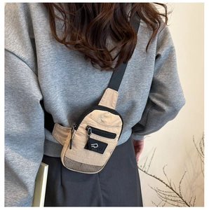 Détail d'un sac bandoulière en nylon beige avec poches zippées et maille noire