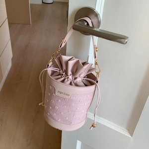 Détail du sac seau rose à cordon avec pois brodés et bandoulière chaîne dorée