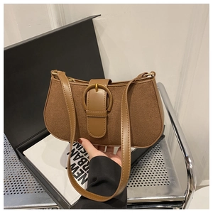 Detail of retro brown suede handbag with a vintage gold buckle and smooth leather handle