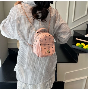 Mini sac à dos rose avec motif ours et bandoulière chaîne porté par un mannequin