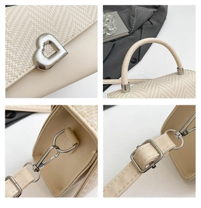 Detail view of the silver heart buckle and beige patchwork texture on the crossbody bag