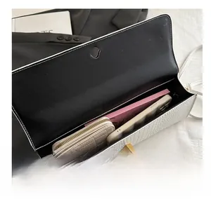 Interior view of white embossed texture handbag showing capacity for phone and wallet