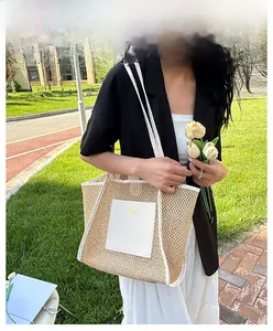 Outdoor shot of a woven mesh tote bag with white leather trim held by a fashion model