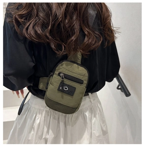 Vue détaillée du petit sac bandoulière en nylon vert olive porté par un mannequin