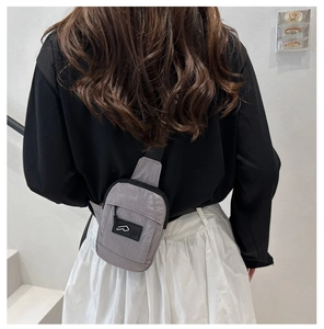 Detail of grey waterproof nylon crossbody bag showing tear-resistant fabric texture