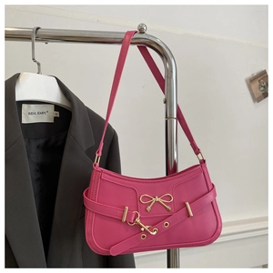 Détail du sac à bandoulière en similicuir rose avec boucle nœud doré et bandoulière