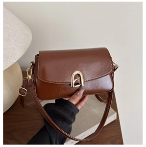 Détail d'un sac à main marron vintage avec fermoir métallique doré en forme de fer à cheval