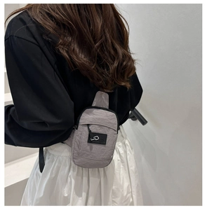 Detail of adjustable black strap and gray nylon fabric on minimalist crossbody bag