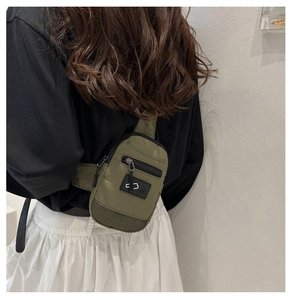 Détail d'un sac de poitrine en nylon vert olive avec sangle et poches multicouches