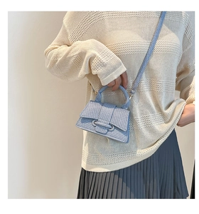 Vue détaillée d'un mini sac bandoulière bleu clair en texture denim porté par un mannequin