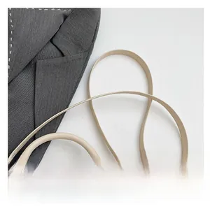 Detail shot of the beige woven handbag featuring comfortable handles and thin shoulder strap