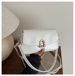 Vue détaillée du sac crème élégant doté d'un fermoir métallique doré en forme d'arche