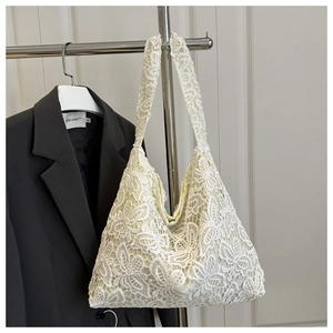 Gros plan détaillé sur la texture dentelle florale 3D d'un sac à main d'été blanc