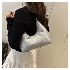 Silver metallic snakeskin hobo bag worn by model, showcasing the textured crescent design