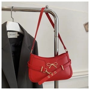 Détail du sac à bandoulière rouge avec boucle dorée et texture en cuir premium
