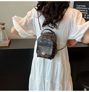 Détail d'un mini sac à dos marron avec imprimé monogramme vintage et boucle dorée