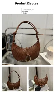 Close-up of coffee brown woven crescent bag showing leather texture and gold D-ring detail