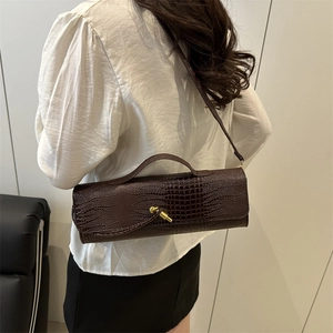 Dark brown faux crocodile cylindrical crossbody bag with gold buckle and top handle
