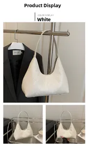 Detail of white snake-embossed shoulder bag with metallic feet and smooth zipper