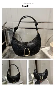 Detail view of black woven moon bag featuring gold horseshoe buckle and knotted handle