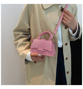 Détail de la texture tissée et du design trapèze structuré du mini sac à main rose