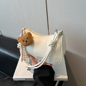 Chic beige half-moon shoulder bag with knot strap and teddy bear charm for women