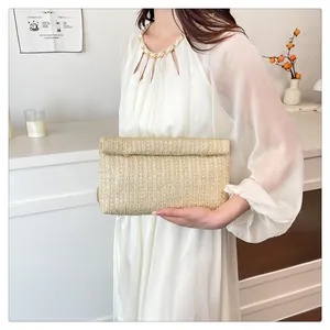 Detail shot of golden woven straw evening clutch bag with elegant gold chain strap