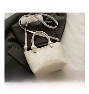 Close-up of white snake pattern texture and knot handle on a small tote bag