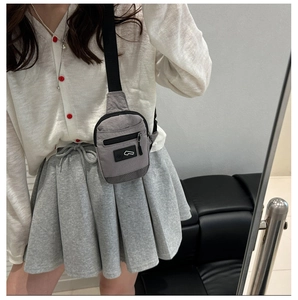 Mini sac bandoulière en nylon gris avec sangle ajustable porté en sac de poitrine chic